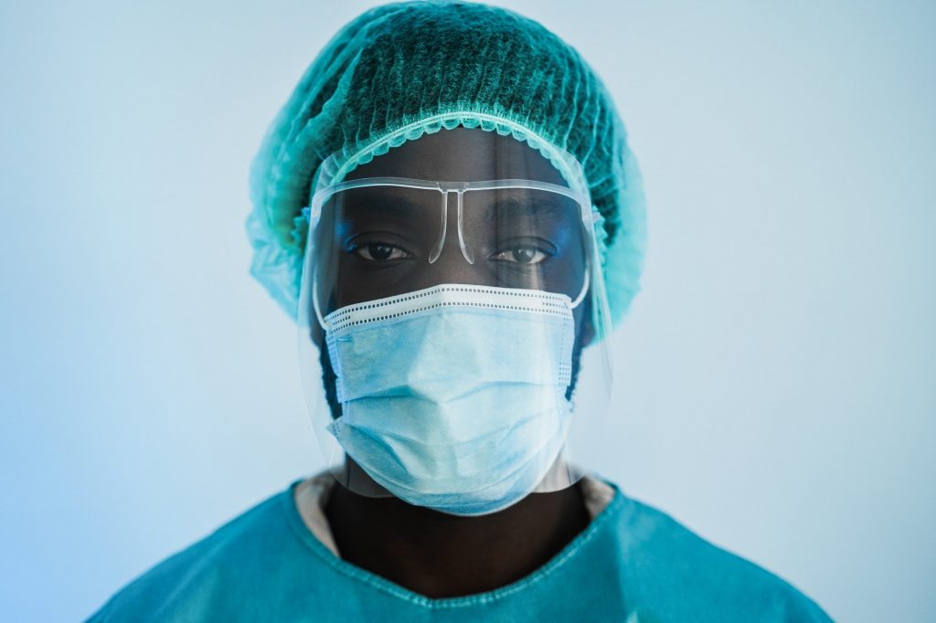 African doctor at work inside hospital during coronavirus outbreak - Focus on mask